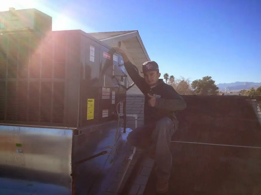 HVAC technician performing AC Tune-Up on a rooftop unit in Marlborough